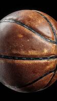 Basketball resting on a black surface highlighting its texture and details at a close range photo