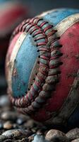 Close-up of a worn baseball showing faded colors and detailed stitching on a gritty surface during an outdoor game photo