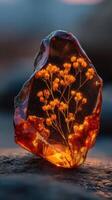 Stunning amber stone encapsulating delicate flowers in a mystical setting at sunset photo