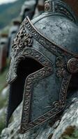 Intricately designed ancient helmet resting on stone in a historical reenactment setting photo