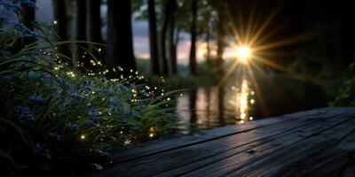 Golden sunset reflecting on calm water with glowing lights and wildflowers by the riverbank in a tranquil forest setting photo