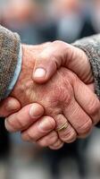 Two hands meet in a firm handshake during a formal greeting outside in a busy urban setting photo