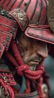 Warrior in detailed red armor stands solemnly during twilight in a historical reenactment setting photo