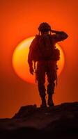 Soldier saluting against a vibrant sunset in a moment of reflection and honor at the edge of the horizon photo