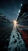 Race track at sunset highlighting wet pavement and bright lights during a motorsport event photo
