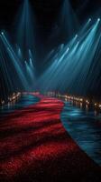 Elegant red carpet runway illuminated by dramatic lighting in a spacious venue during a high-profile event at night photo