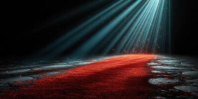 Red pathway illuminated in darkness with beams of light shining from above photo