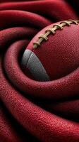 Close-up of a textured football intertwined with a red fabric, showcasing the details of the game equipment and its surroundings photo