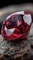 Red gemstone glimmers on rough stone surface under soft lighting creating an elegant display of color and brilliance photo