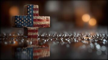 Decorative wooden cross with American flag design on wet surface with bokeh lights in background photo