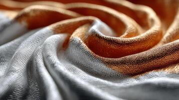 Elegant fabric texture showcasing silver and copper hues in a smooth, swirling arrangement photo