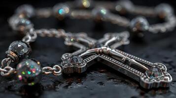 Elegant silver rosary beads with sparkling details on a reflective black surface photo