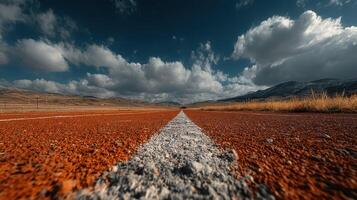 Scenic view of an empty road stretching through a dramatic landscape under a cloudy sky during the golden hour photo