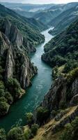 Serene river winding through rugged mountains under a cloudy sky in the heart of nature photo