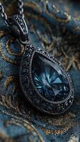 Elegant teardrop pendant resting on richly patterned fabric with intricate design details in a soft lighting environment photo
