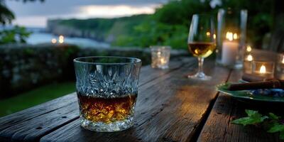 Evening gathering by the sea with drinks and candlelight at a rustic wooden table photo