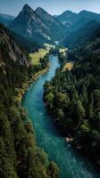 Serene river winding through lush green valley surrounded by majestic mountains on a clear sunny day photo