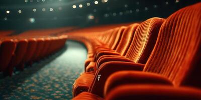 Empty red theater seats in a well-lit auditorium with a smooth carpet showcasing a quiet moment before the show starts photo