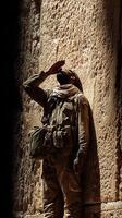 Soldier standing by ancient stone columns in a moment of reflection during sunset photo
