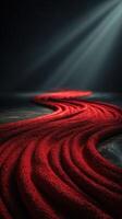 Flowing red textile creating a vivid path in dark surroundings with dramatic lighting illuminating the texture photo