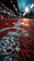 Track surface with starting line markings and blurred spectators in the background during a cloudy day photo