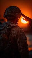 Soldier salutes at sunset during a military ceremony in a scenic location photo