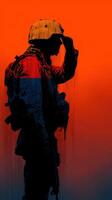 Silhouette of a soldier saluting against a vibrant sunset background in a military setting photo
