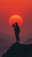 Soldier salutes against a stunning sunset backdrop in a mountainous landscape, highlighting bravery and honor photo