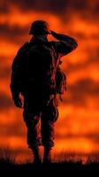 Soldier salutes at sunset with vibrant sky in background during a moment of reflection and remembrance photo