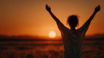Woman enjoys sunset view while celebrating freedom in a serene outdoor setting photo
