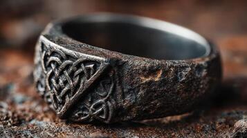 Intricate celtic design on an aged silver ring showcased on a rustic surface photo