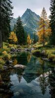 Autumn landscape with vibrant trees reflecting in a clear stream beneath a towering mountain photo
