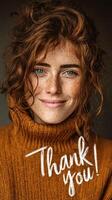 Smiling woman with curly red hair and freckles expressing gratitude while wearing a cozy sweater photo