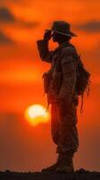 Soldier saluting against a vibrant sunset on a military training field photo