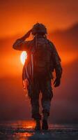 Soldier saluting the sunset while holding an American flag on a quiet battlefield photo