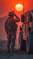 Soldier saluting at sunset near military vehicle in rugged terrain photo