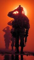 Soldiers saluting at sunset during a training exercise in arid terrain photo