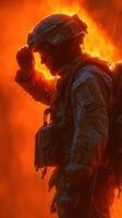 Soldier salutes against fiery backdrop during intense military operation at dusk in a combat zone photo