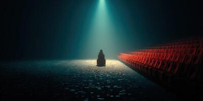 Light shines on a solitary figure seated in an empty theater during a dramatic performance at night photo