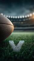 Close-up of a rugby ball resting on grass with a V marking at a stadium during an evening match photo