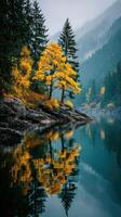 Vibrant autumn foliage reflecting on a tranquil lake surrounded by mountains in early morning light photo