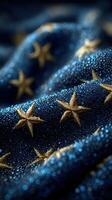 Golden stars shimmer on a blue fabric adorned with beads of moisture captured in the soft light of early morning photo