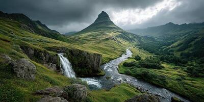 Majestic waterfall cascading down a rocky cliff in a lush green valley surrounded by dramatic mountains photo
