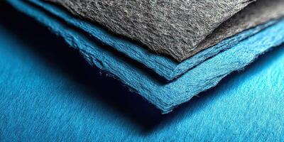 Colorful layers of textured paper stacked on a flat surface create an artistic visual effect in a well-lit workspace photo
