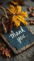 Thank you note with autumn leaves on rustic surface featuring warm colors and cozy vibes in fall season photo