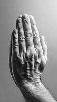 Hands together in a gesture of prayer or reflection captured in black and white during a quiet moment photo