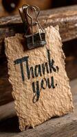 Message of gratitude displayed on rustic paper with a wooden clip, ideal for expressing thanks in various settings photo