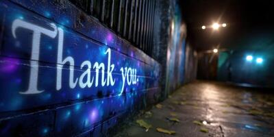 Colorful thank you message on a brick wall in a dimly lit urban alleyway at night photo