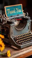 Vintage typewriter adorned with a thank you note on a rustic table, illuminated by warm light showcasing its intricate details photo