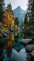 Autumn colors reflect on a serene river in the mountains during early morning light photo